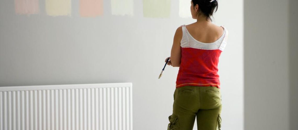 diy,woman,choosing,paint,color,swatches,on,room,wall,deciding